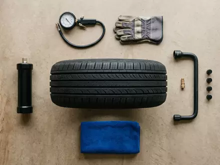 Flatlay-Arrangement rund um Ganzjahresreifen zum Thema Goodyear Vector 4Seasons, ISIN US3825501014, weiches Oberlicht - Foto: THN