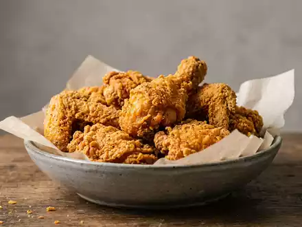 Fotorealistische Studioaufnahme von Frittiertes Hähnchen zum Thema KFC Bucket, ISIN US9884981013, klare Lichtfuehrung - Foto: THN