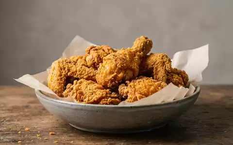 Fotorealistische Studioaufnahme von Frittiertes Hähnchen zum Thema KFC Bucket, ISIN US9884981013, klare Lichtfuehrung - Foto: THN
