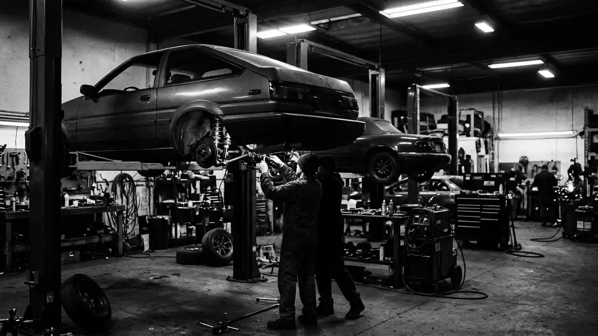 Schwarzweiss-Reportagebild mit Sportcoupé in dokumentarischer Arbeitsumgebung, neutral