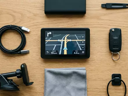 Flatlay-Arrangement rund um Navigationsgerät zum Thema TomTom GO Navigation, ISIN NL0000387058, weiches Oberlicht - Foto: THN