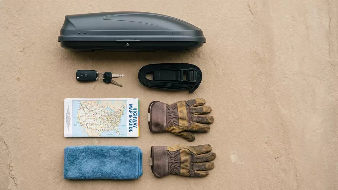Flatlay-Arrangement rund um Dachbox mit passenden Requisiten von oben, neutral