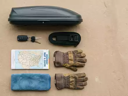 Flatlay-Arrangement rund um Dachbox zum Thema Thule Dachbox, ISIN SE0006422390, weiches Oberlicht - Foto: THN