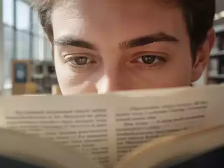 Nahaufnahme einer Person, die in einem hellen Raum konzentriert in einem Buch liest, Fokus auf die Augenpartie. - Foto: über boerse-global.de