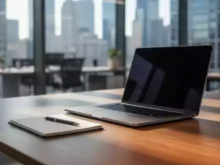 Ein moderner, leicht unscharfer Schreibtisch in einem Bürogebäude mit Laptop und Notizblock bei natürlichem Tageslicht. - Foto: über boerse-global.de