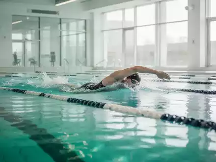 Eine Person beim Schwimmen in einem hellen Hallenbad zur therapeutischen Behandlung von Gelenkbeschwerden. - Foto: über boerse-global.de