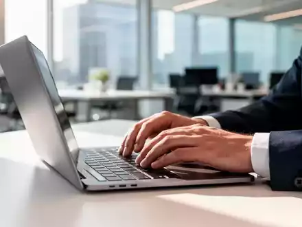Nahaufnahme einer Person, die an einem Laptop in einem modernen Büro arbeitet, um die Einführung von Passkeys zu symbolisieren. - Foto: über boerse-global.de