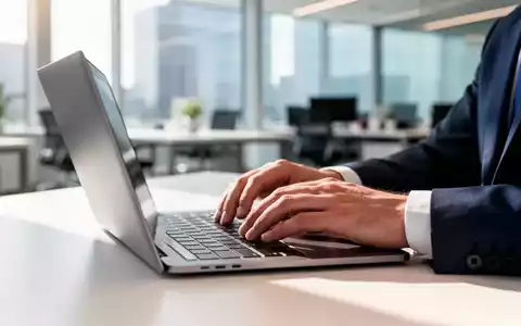 Nahaufnahme einer Person, die an einem Laptop in einem modernen Büro arbeitet, um die Einführung von Passkeys zu symbolisieren. - Foto: über boerse-global.de
