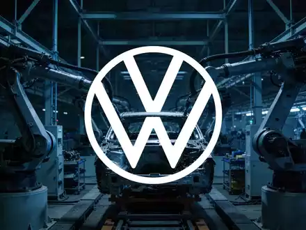Industrielle Fertigungshalle in gedimmtem Licht, die eine angespannte und herausfordernde Stimmung in der Automobilbranche zeigt. - Foto: über boerse-global.de