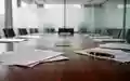 Ein moderner Konferenztisch in einem hellen Büro mit verwaschenen juristischen Unterlagen im Hintergrund. - Foto: über boerse-global.de