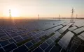 Weitläufiger Solarpark bei Sonnenaufgang mit Photovoltaik-Modulen und Strommasten in der Ferne. - Foto: über boerse-global.de