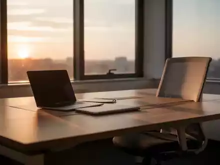 Ein aufgeräumter, leerer Büroarbeitsplatz mit einem zugeklappten Laptop in warmem, natürlichem Licht am späten Nachmittag. - Foto: über boerse-global.de