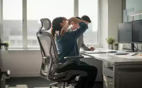 Eine Person an einem modernen, ergonomischen Arbeitsplatz in einem hellen Büro, Fokus auf gesundheitsfördernde Arbeitsbedingungen. - Foto: über boerse-global.de