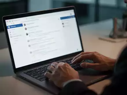 Person an einem Laptop in einem Büro, die eine verdächtige E-Mail prüft, um sich vor Phishing-Angriffen zu schützen. - Foto: über boerse-global.de