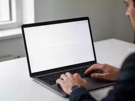 Eine Person nutzt einen Laptop in einem hellen Büro, wobei der Fokus auf einem minimalistischen Suchfeld auf dem Bildschirm liegt. - Foto: über boerse-global.de
