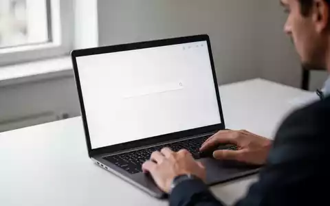 Eine Person nutzt einen Laptop in einem hellen Büro, wobei der Fokus auf einem minimalistischen Suchfeld auf dem Bildschirm liegt. - Foto: über boerse-global.de