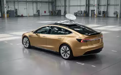 Ein goldenes autonomes Cybercab mit integrierter Starlink-Antenne auf dem Boden einer modernen Fabrikhalle. - Foto: über boerse-global.de