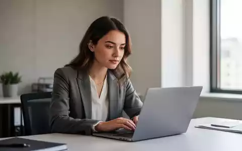 Eine junge Gründerin arbeitet konzentriert an ihrem Laptop in einem modernen, hellen Büro. - Foto: über boerse-global.de