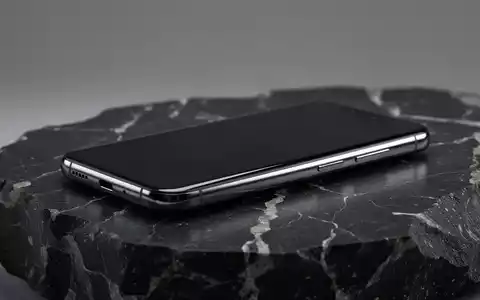 Ein hochwertiges, modernes Smartphone auf einer dunklen, texturierten Oberfläche in einer professionellen Studioaufnahme. - Foto: über boerse-global.de