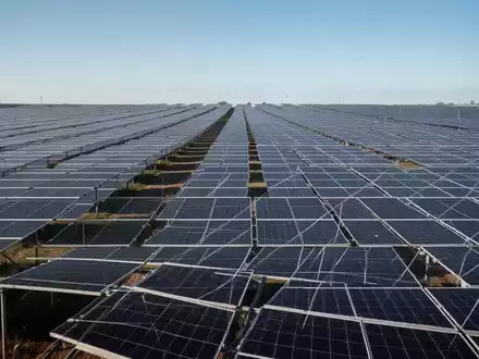 Moderne Solarpark-Anlage mit zahlreichen Photovoltaik-Modulen unter strahlend blauem Himmel. - Foto: über boerse-global.de