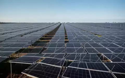 Moderne Solarpark-Anlage mit zahlreichen Photovoltaik-Modulen unter strahlend blauem Himmel. - Foto: über boerse-global.de