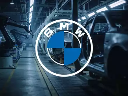 Abstrakte Darstellung einer modernen Automobilfertigung in einer Industriehalle mit atmosphärischer Beleuchtung. - Foto: über boerse-global.de