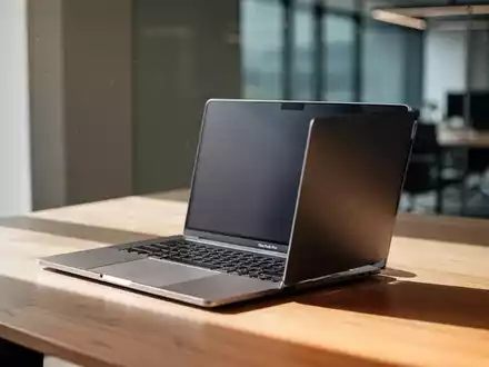 Ein silbernes MacBook Pro auf einem modernen Schreibtisch in einem hellen, professionellen Büro. - Foto: über boerse-global.de