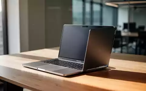 Ein silbernes MacBook Pro auf einem modernen Schreibtisch in einem hellen, professionellen Büro. - Foto: über boerse-global.de