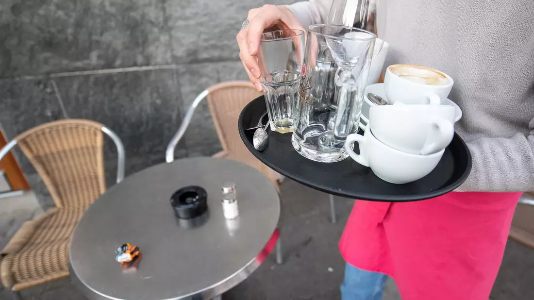 Klassischer Studentenjob: Ein Kellner räumt einen Tisch in einem Restaurant ab. (Symbolbild) - Bild: Sebastian Gollnow/dpa