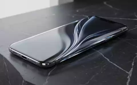 Ein rahmenloses Smartphone mit gewölbtem Glasgehäuse auf einer dunklen, polierten Oberfläche. - Foto: über boerse-global.de
