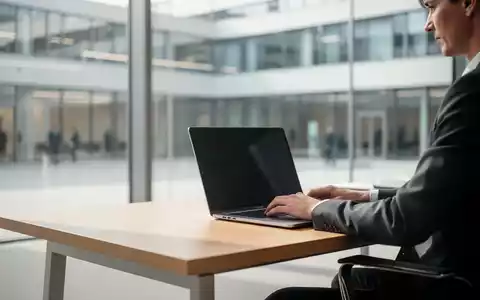 Eine Person arbeitet in einem modernen, hellen Büro an einem Laptop, umgeben von einer zeitgemäßen Behördenarchitektur. - Foto: über boerse-global.de