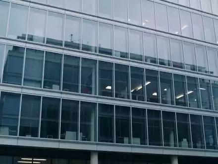 Modernes Bürogebäude einer Immobilienfirma bei bewölktem Himmel. - Foto: über boerse-global.de
