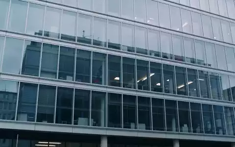 Modernes Bürogebäude einer Immobilienfirma bei bewölktem Himmel. - Foto: über boerse-global.de