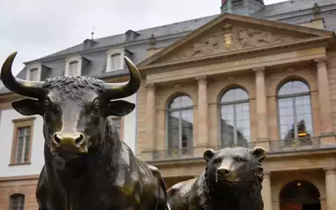 Die Fassade der Frankfurter Börse mit den Statuen von Bulle und Bär vor einem bewölkten Himmel. - Foto: über boerse-global.de