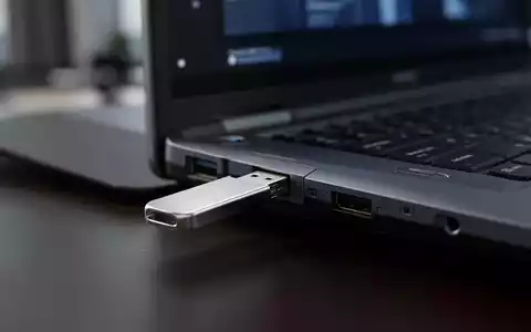 Nahaufnahme eines USB-Sticks, der in den Anschluss eines Business-Laptops eingesteckt wird, in einer Büroumgebung. - Foto: über boerse-global.de