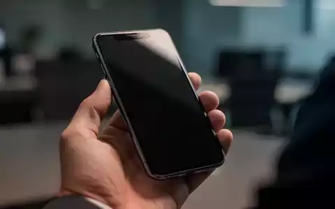 Nahaufnahme einer Person, die ein Smartphone in einer professionellen Büroumgebung prüft. - Foto: über boerse-global.de
