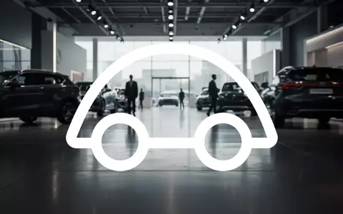 Abstraktes Bild eines modernen Autohauses mit verschwommenen Fahrzeugsilhouetten in stimmungsvollem Licht. - Foto: über boerse-global.de