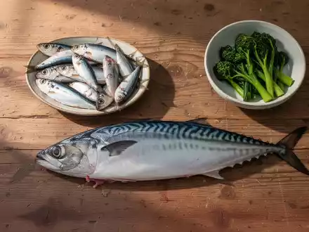 Frischer Fisch wie Makrele und Sardinen auf einem Holztisch als natürliche Quellen für Omega-3-Fettsäuren. - Foto: über boerse-global.de