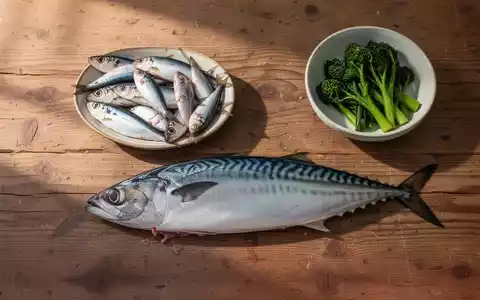 Frischer Fisch wie Makrele und Sardinen auf einem Holztisch als natürliche Quellen für Omega-3-Fettsäuren. - Foto: über boerse-global.de