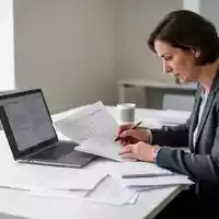 Eine Person sitzt an einem Schreibtisch und arbeitet konzentriert an Unterlagen zur beruflichen Weiterbildung. - Foto: über boerse-global.de