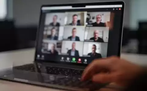 Nahaufnahme eines Laptops mit verschwommener Videokonferenz-Oberfläche in einem abgedunkelten Büro. - Foto: über boerse-global.de