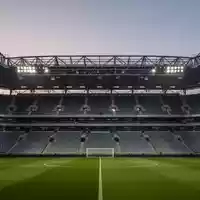 Leeres Fußballstadion in der Abenddämmerung mit Fokus auf die moderne Sicherheitsinfrastruktur und Architektur. - Foto: über boerse-global.de