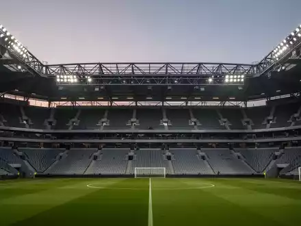 Leeres Fußballstadion in der Abenddämmerung mit Fokus auf die moderne Sicherheitsinfrastruktur und Architektur. - Foto: über boerse-global.de