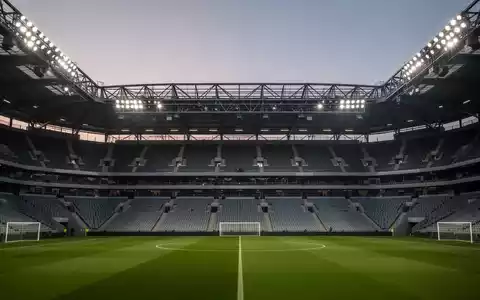 Leeres Fußballstadion in der Abenddämmerung mit Fokus auf die moderne Sicherheitsinfrastruktur und Architektur. - Foto: über boerse-global.de