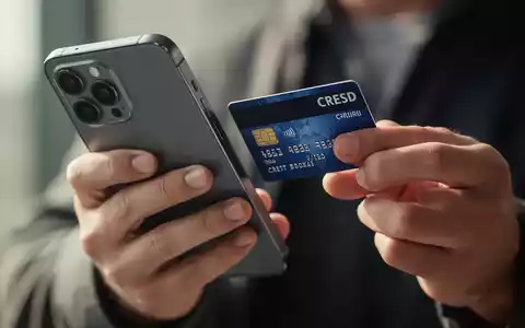 Eine Person hält eine Bankkarte nah an die Rückseite eines Smartphones, um eine kontaktlose Transaktion durchzuführen. - Foto: über boerse-global.de