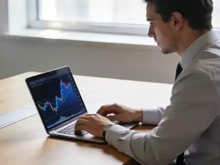 Ein Investor arbeitet an einem Laptop in einem modernen, hellen Büro mit Blick auf Finanzmarktdaten. - Foto: über boerse-global.de