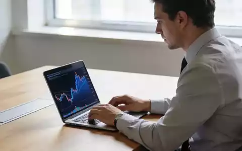 Ein Investor arbeitet an einem Laptop in einem modernen, hellen Büro mit Blick auf Finanzmarktdaten. - Foto: über boerse-global.de