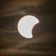Der Beginn einer partiellen Sonnenfinsternis ist am Himmel über Dresden zu sehen. - Bild: Robert Michael/dpa