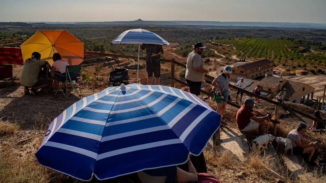 Menschen versammeln sich in Spanien am höchsten Punkt des Dorfes Llardecans vor der Sonnenfinsternis. - Bild: Jordi Boixareu/ZUMA Press Wire/dpa