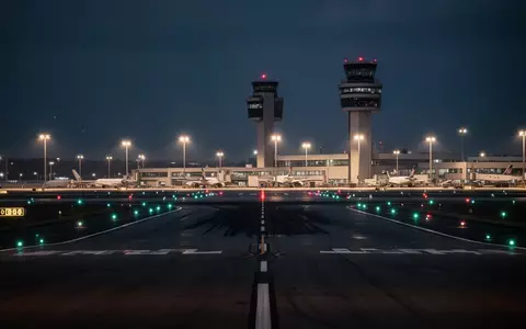 Ein nächtlicher Blick auf die Rollbahnen eines Verkehrsflughafens mit beleuchtetem Tower in der Ferne. - Foto: über boerse-global.de